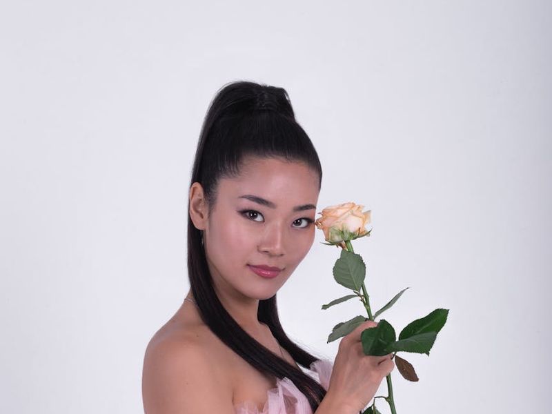 A person in a calm, focused pose in a minimalist, well-lit room.